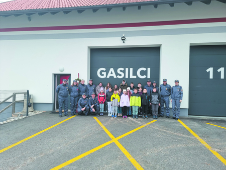 Skupina gasilcev in otrok pred gasilnim domom. Foto: Dejan Jakopin.