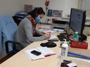 Oseba v pisarni, ki sprejema klice za naročilo zdravil