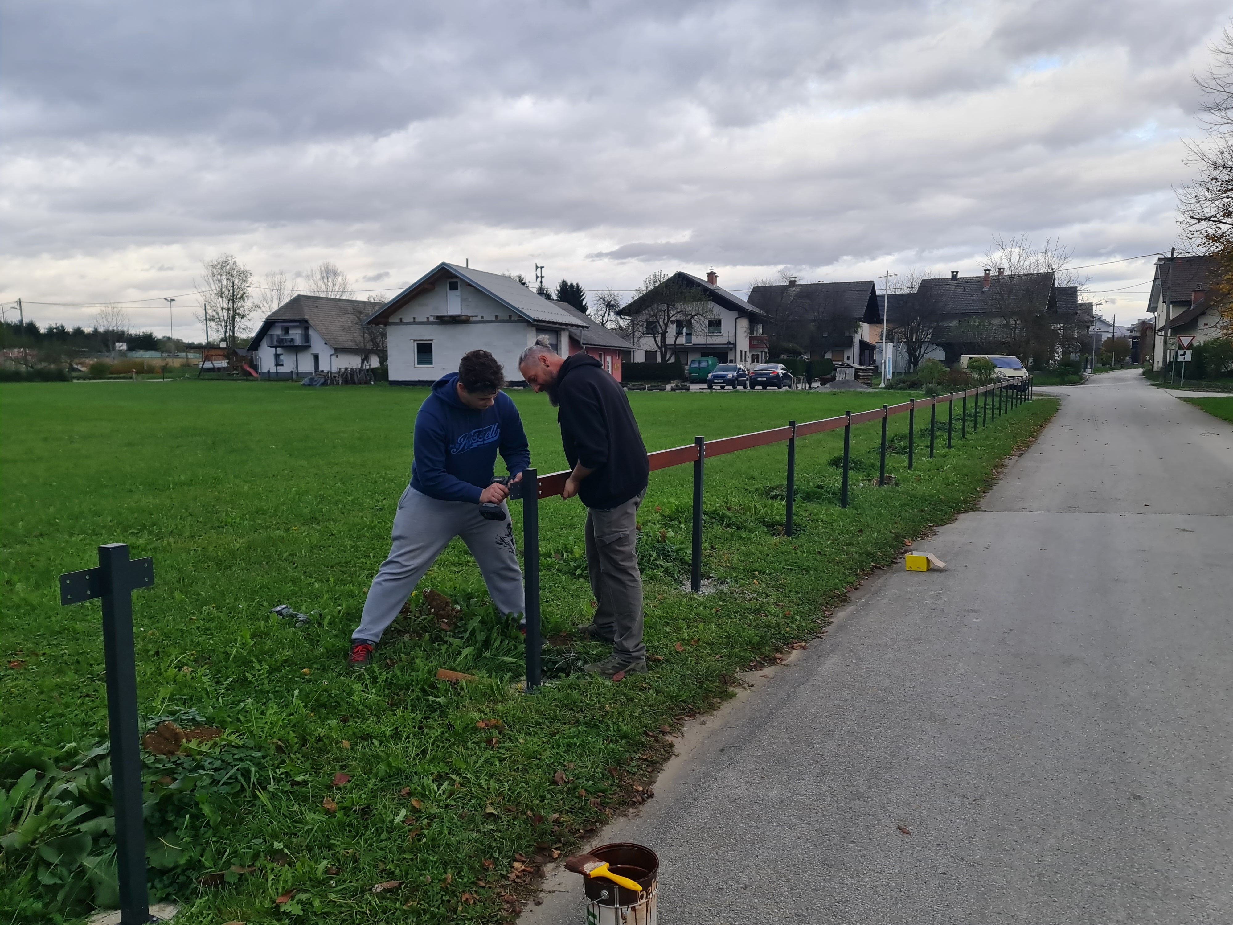 Dva mo&scaron;ka postavljata leseno ograjo ob cesti